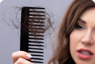 Mujer peinandose y el peine con pelos que se caen